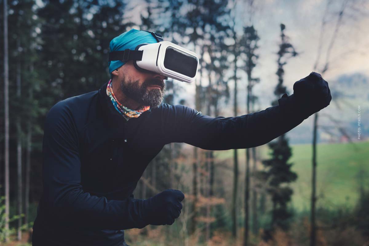 VR-virtual-reality-man-wearing-vr-glasses-in-a-forest-cap-gloves-movement